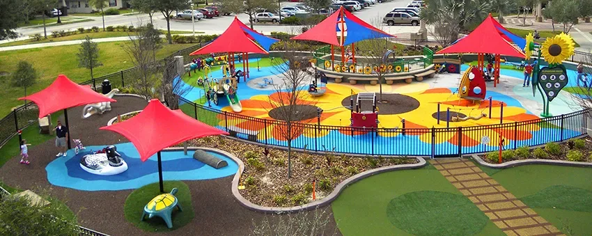 Playground em Barnett Park com toldos vermelhos, escorregadores e brinquedos interativos