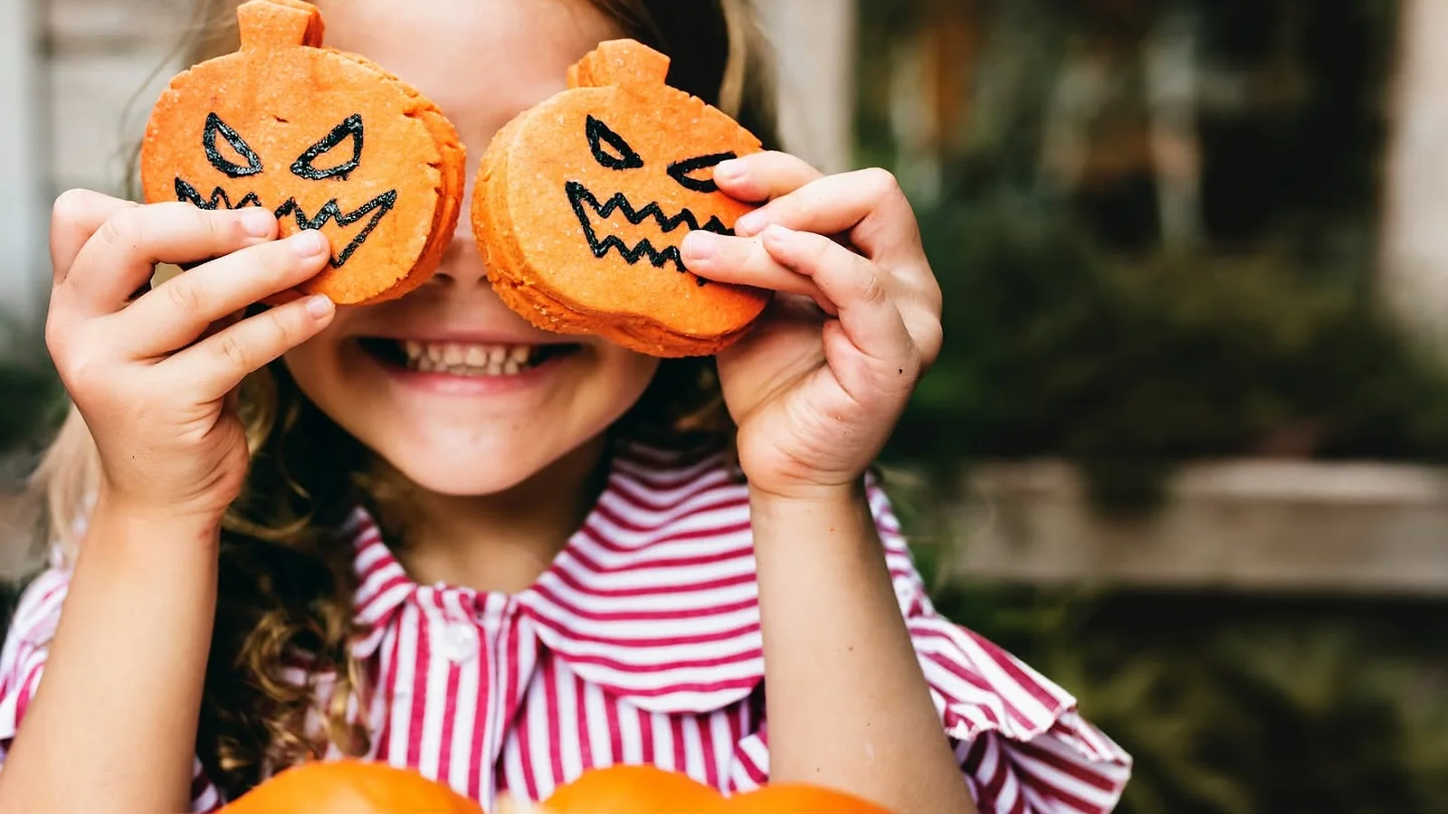 Criança com doces de abóbora em celebração de Halloween