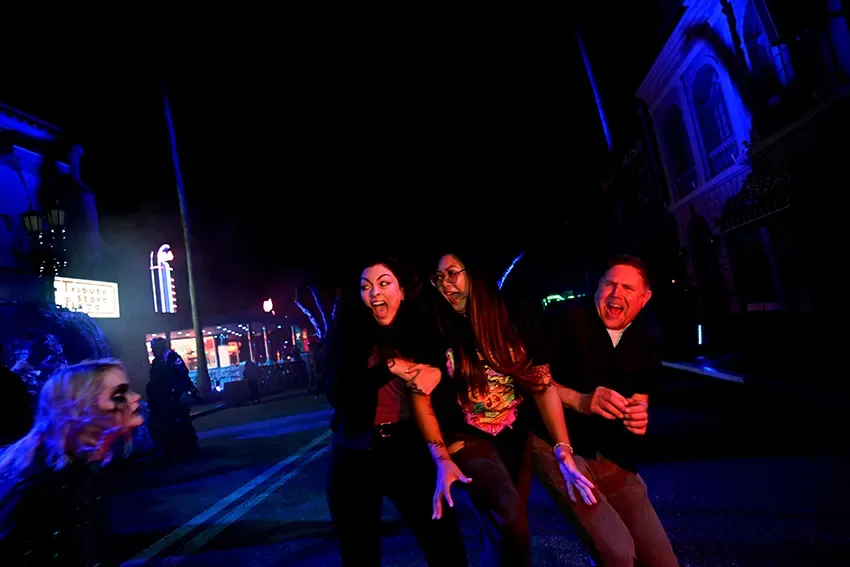 Visitantes gritam de susto em zona assombrada durante o Halloween Horror Nights 2025 na Universal Orlando.