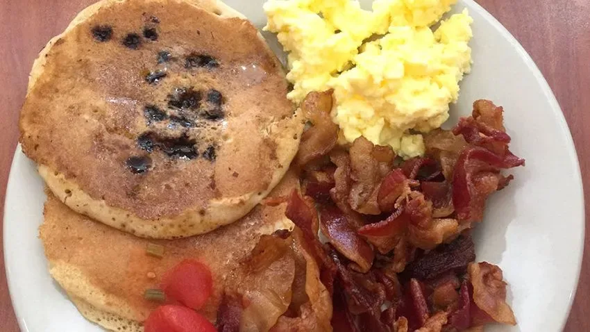 Prato com panquecas, ovos mexidos e bacons que fazem parte da variedade de pratos quentes da Ponderosa Steakhouse, em Orlando