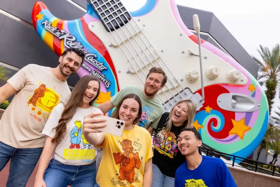 Amigos tiram selfie em frente à guitarra da nova atração Rock'n' Roller Coaster