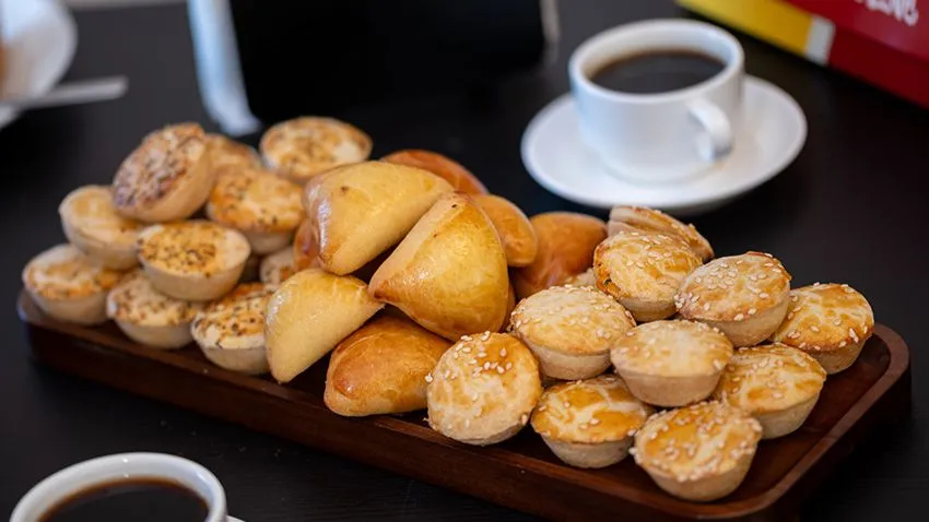 Mesa com salgados para o café da manhã da Love Snacks Coxinha & Cia, em Orlando, com coxinhas, esfihas e empadas