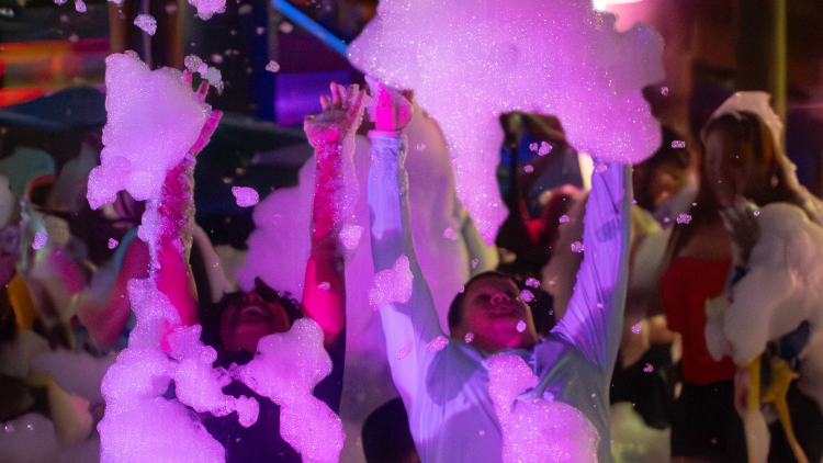 Kids have fun in a pool with soap bubbles