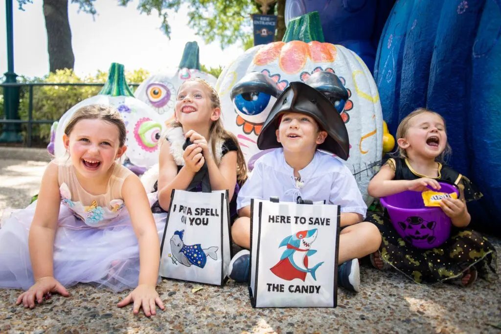 Children sitting with bags collecting candy at SeaWorld Orlando's Halloween party