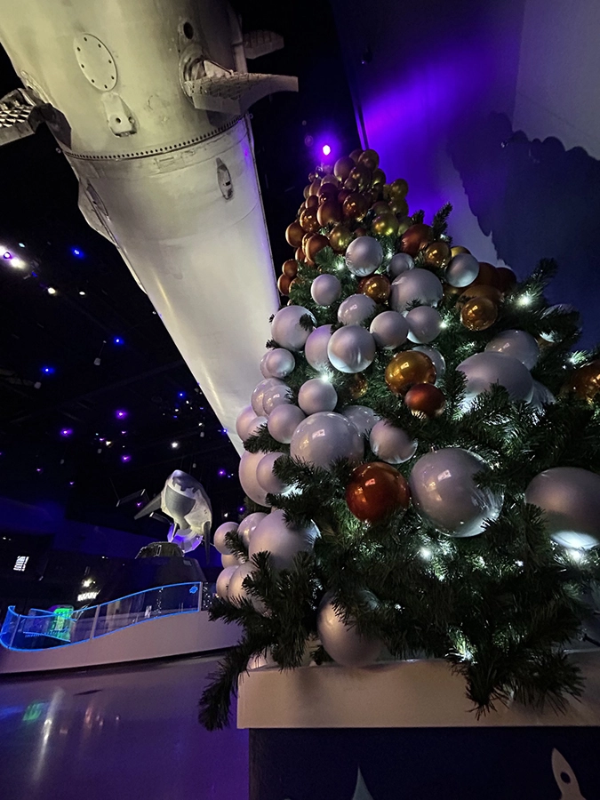 Christmas tree with rocket in the background at Kennedy Space Center