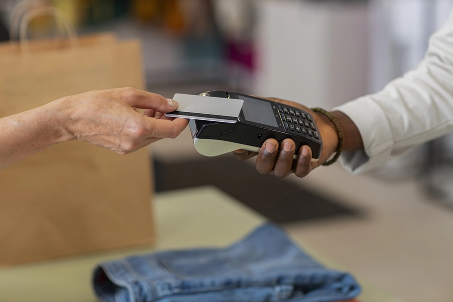 Cliente realiza pagamento via cartão de crédito em loja de roupas na Flórida durante período de isenção de impostos