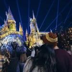 Casal assiste ao espetáculo noturno de projeção em frente ao castelo de Harry Potter na Universal Orlando Resort
