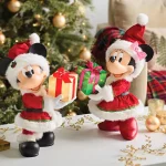 Mickey e Minnie com trajes natalinos trocando presentes em frente a uma árvore de Natal